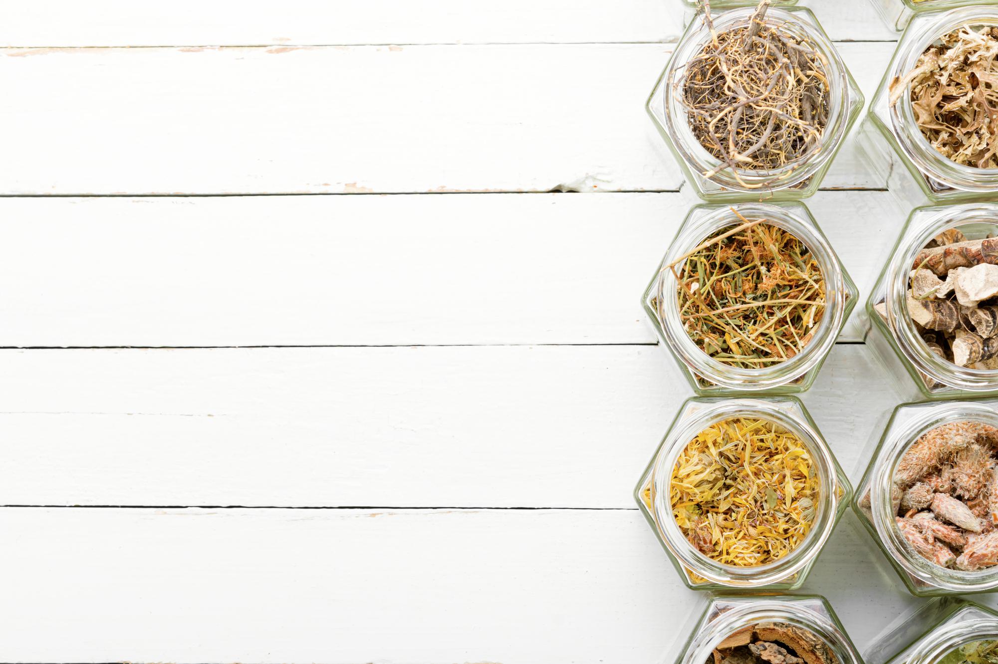 wooden kitchen board with herbs and crafted jars
